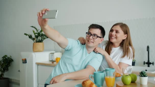 Esposo y esposa tomando selfie en la cocina se divierten con la cámara del teléfono inteligente — Vídeos de Stock