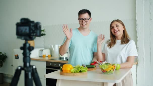 Счастливая семья записывает видео об экологически чистых овощах, разговаривая на камеру — стоковое видео