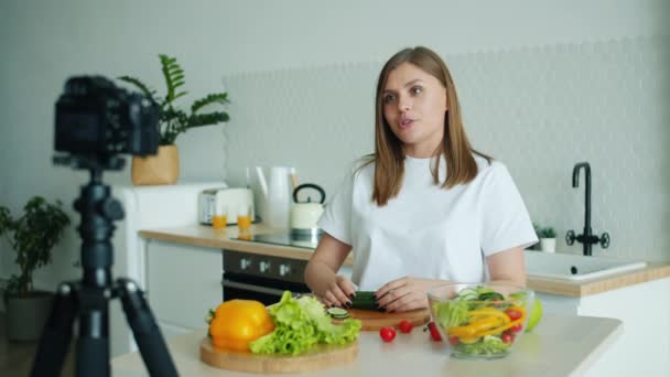 Ama de casa grabación de vídeo en la cocina en casa mostrando los pulgares hacia arriba cocinar alimentos — Vídeos de Stock