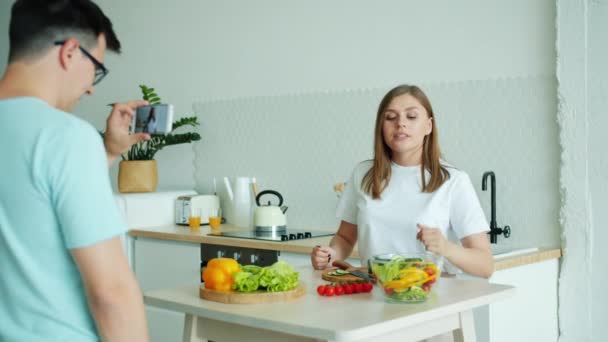 Familia de vloggers grabando video en cocina cocinando alimentos usando smartphone — Vídeos de Stock