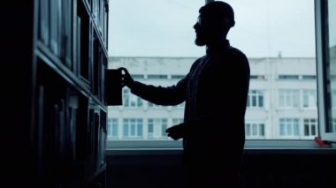 Üniversite kütüphanesiokuma kitaplarından bakan erkek öğrencisilueti
