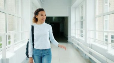 Mutlu karışık yarış kız üniversitede yürüyen kız öğrenci ile yüksek beş yapıyor