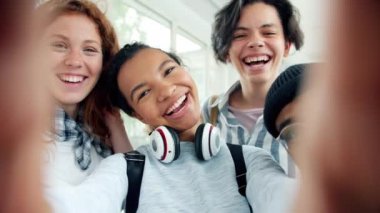 Birlikte selfie çekerken kapalı mekanda kameraya poz veren mutlu gençlerin portresi