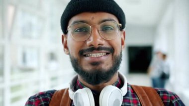 Üniversitede gülümseyen neşeli Afro-Amerikan erkek öğrencinin yakın çekim portresi