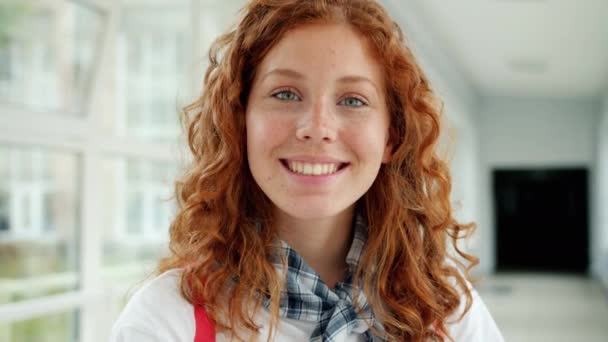 Slow motion gros plan portrait de jolie adolescente souriant dans le hall de l'école — Video