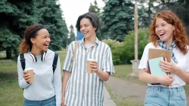 Jovem alegre rindo se divertindo andando ao ar livre com livros e ir café — Vídeo de Stock