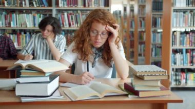 Uykulu bayanın kütüphanede çalışıp sonra da masanın üstünde uyuması.