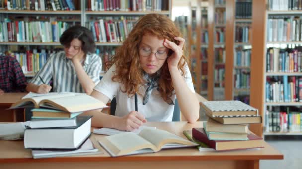 Mouvement lent de dame endormie travaillant dans la bibliothèque puis dormir tête sur le bureau — Video