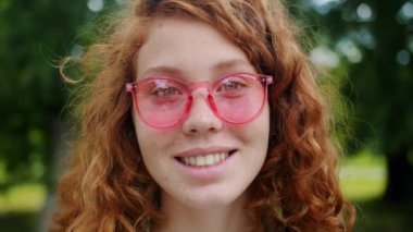 Parkta güneş gözlüğü takan çiller ile güzel kızıl kız yakın çekim
