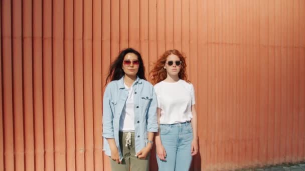 Retrato de mujeres jóvenes paradas al aire libre mirando a la cámara con caras serias — Vídeos de Stock