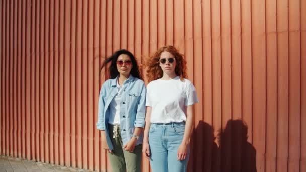 Retrato de chicas serias de pie al aire libre en gafas de sol mirando a la cámara — Vídeo de stock