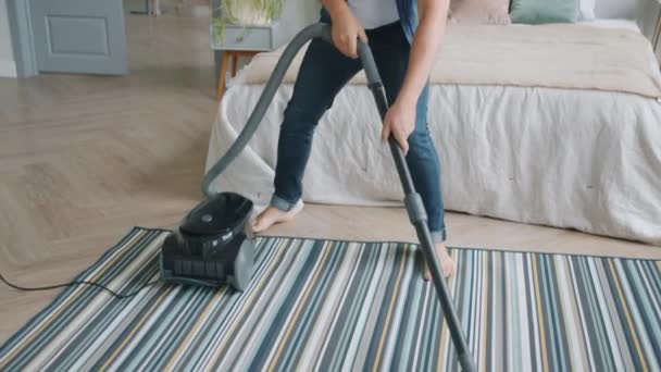 Bonito jovem limpando casa com aspirador de pó e dançando sozinho — Vídeo de Stock