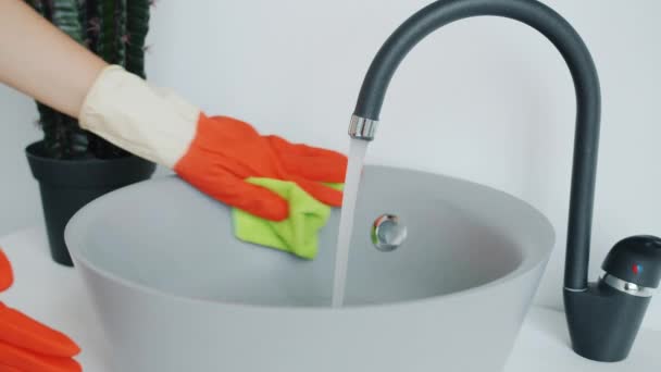 Primer plano de las manos femeninas en guantes de goma lavabo de baño con paño húmedo — Vídeos de Stock