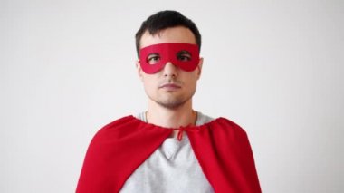 Süpermen kostümlü genç adam portresi. Kırmızı maske ve pelerin. Kameraya bakıyor.