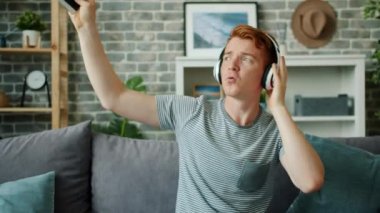 Kulaklıkla müzik dinleyen mutlu bir gencin ağır çekimleri.