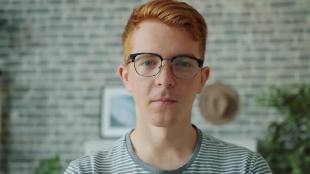 Close-up portrait of teenager looking at camera with serious face then smiling — Stock Video