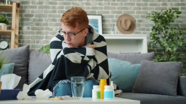 Sjuk tonåring soffa nysningar i pappersnäsduk på soffan täckt med filt — Stockvideo