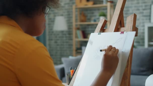 Slow motion van Afro-Amerikaanse meisje tekenen bloemen met potlood thuis glimlachen — Stockvideo