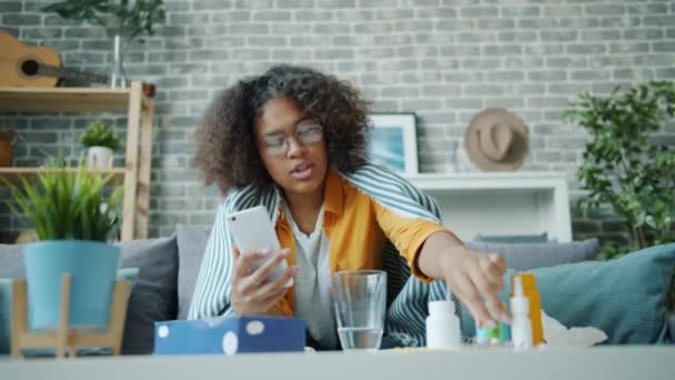 Estudiante enfermo hablando en línea con el médico obtener consulta de vídeo en el teléfono inteligente — Vídeos de Stock