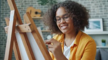 Stüdyoda resim çizen genç kızın yavaş çekimleri yaratıcı işten zevk alıyor.