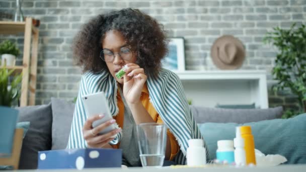 Mujer afroamericana haciendo videollamada a médico consultoría mostrando pastillas — Vídeos de Stock