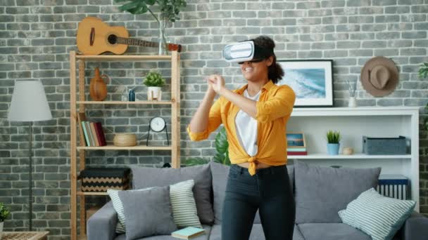 Slow motion of happy young woman playing game wearing virtual reality glasses — Stock Video