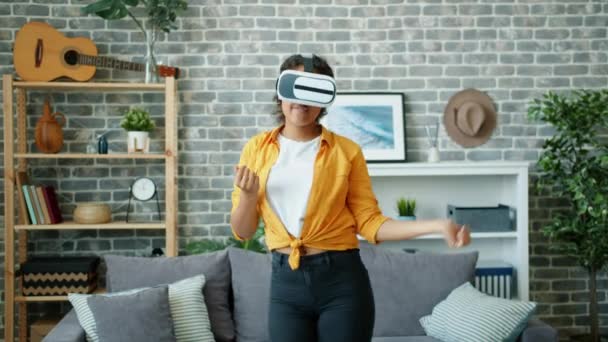 Happy African American woman dancing in virtual reality glasses at home — Stock Video