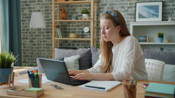 Estudante mulher muito jovem estudando em casa usando laptop digitação escrita — Vídeo de Stock