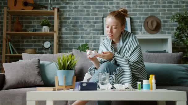 Portret van tiener meisje dat pil voelt zich ziek thuis houden thermometer — Stockvideo