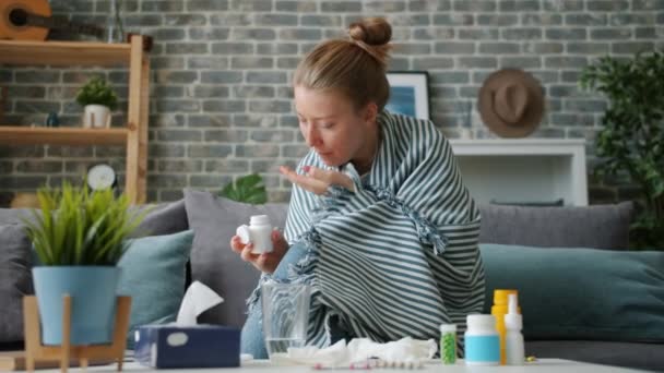 Zeitlupe: Mädchen nimmt Medikamente und trinkt Wasser in Wohnung — Stockvideo