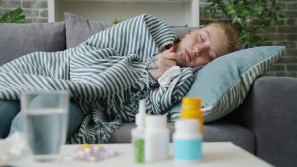 Movimiento lento del adolescente enfermo que toma la temperatura corporal con termómetro en casa — Vídeos de Stock