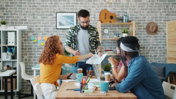 Grupo de colegas discutiendo trabajo en reunión hablando riendo mirando gráfico — Vídeos de Stock