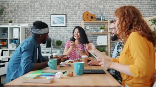 Grupo de jóvenes felices hablando riendo trabajando en el escritorio en la oficina — Vídeo de stock