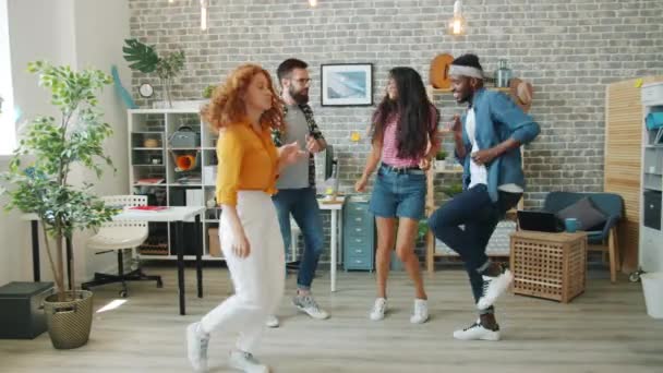 Радісні колеги співробітники танцюють на корпоративній вечірці сміючись розважаються — стокове відео