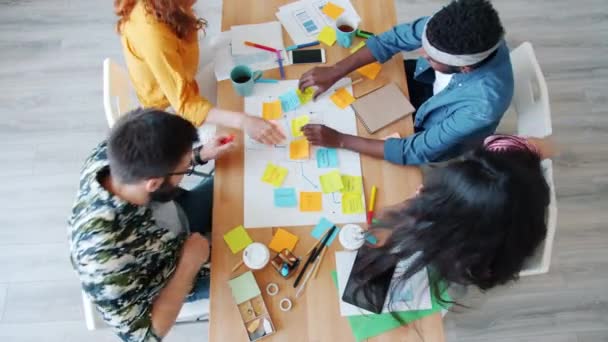 Cámara lenta de las niñas y los chicos corriendo al escritorio haciendo collage compartir ideas — Vídeos de Stock