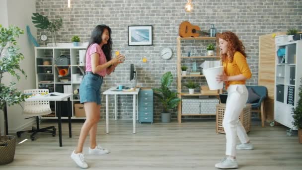 Chicas alegres jugando baloncesto en la oficina tirando papel en la basura riendo — Vídeos de Stock