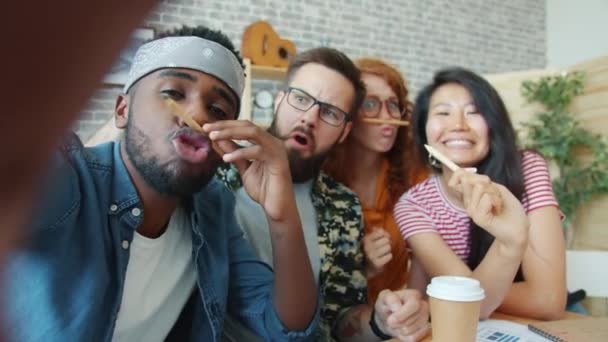 POV de jeunes prenant selfie au bureau regardant la caméra s'amuser avec des crayons — Video