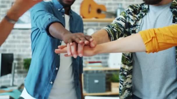 Férfiak és nők csapatának tagjai egymás kezét fogva táncolnak az irodában — Stock videók
