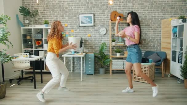 Señoras jóvenes lanzando bolas de papel en la cesta en la oficina disfrutando de divertido juego — Vídeo de stock