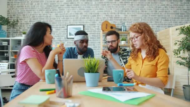 Equipe alegre de trabalhadores de escritório falando olhando para a tela do laptop trabalhando juntos — Vídeo de Stock
