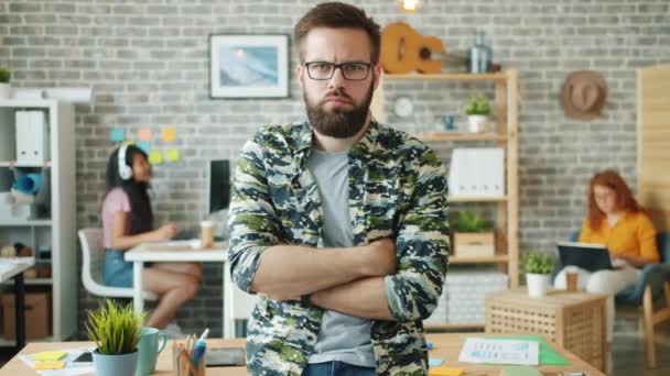 Portret van een man op het werk met gekruiste armen kijkend naar de camera — Stockvideo