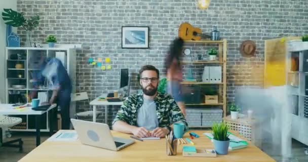 Zoom-in time lapse porträtt av ung entreprenör sitter vid skrivbordet på kontoret — Stockvideo