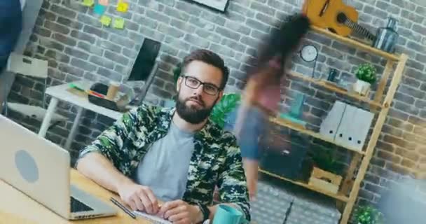 Rotující časový odstup ambiciózního seriózního podnikatele sedícího u stolu v kanceláři — Stock video