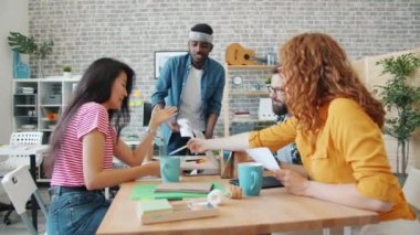 African American man group leader talking to creative team about smartphone app