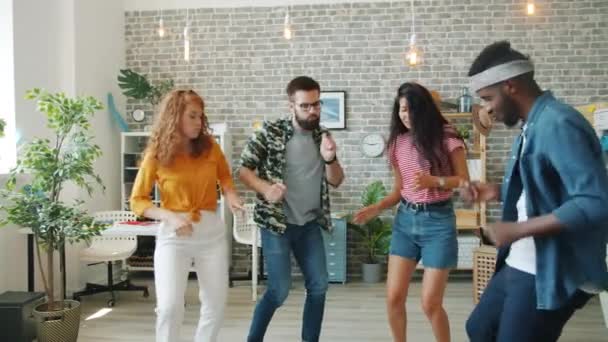 Cámara lenta de chicas creativas y chicos bailando en la oficina divirtiéndose juntos — Vídeos de Stock