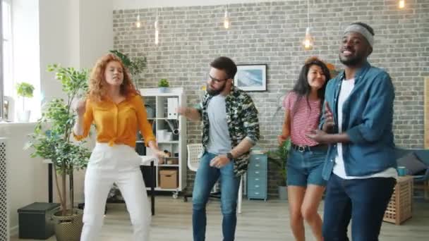 Heureux jeunes hommes et femmes chantant et dansant au bureau s'amusant ensemble — Video