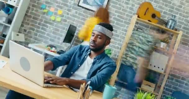 Spinning-Zeitraffer eines afroamerikanischen Unternehmers, der im Büro auf Laptop tippt — Stockvideo