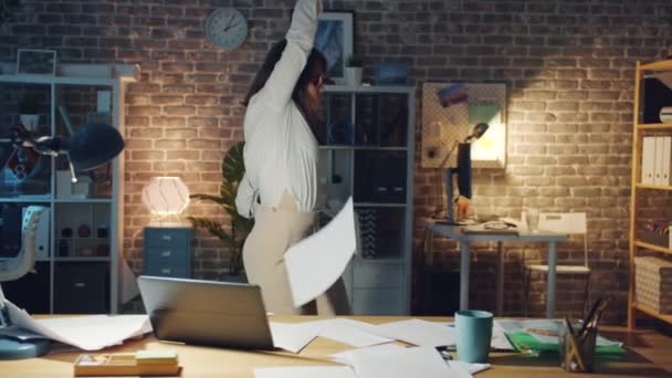 Cheerful manager dancing in office in the evening throwing documents having fun — Stock Video