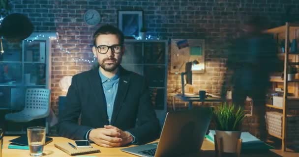 Time lapse of male office worker sitting at desk in dark room late in night — Stock video