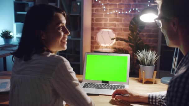 Сотрудники офиса обсуждают бизнес глядя на зеленый экран копировального пространства ноутбука — стоковое видео